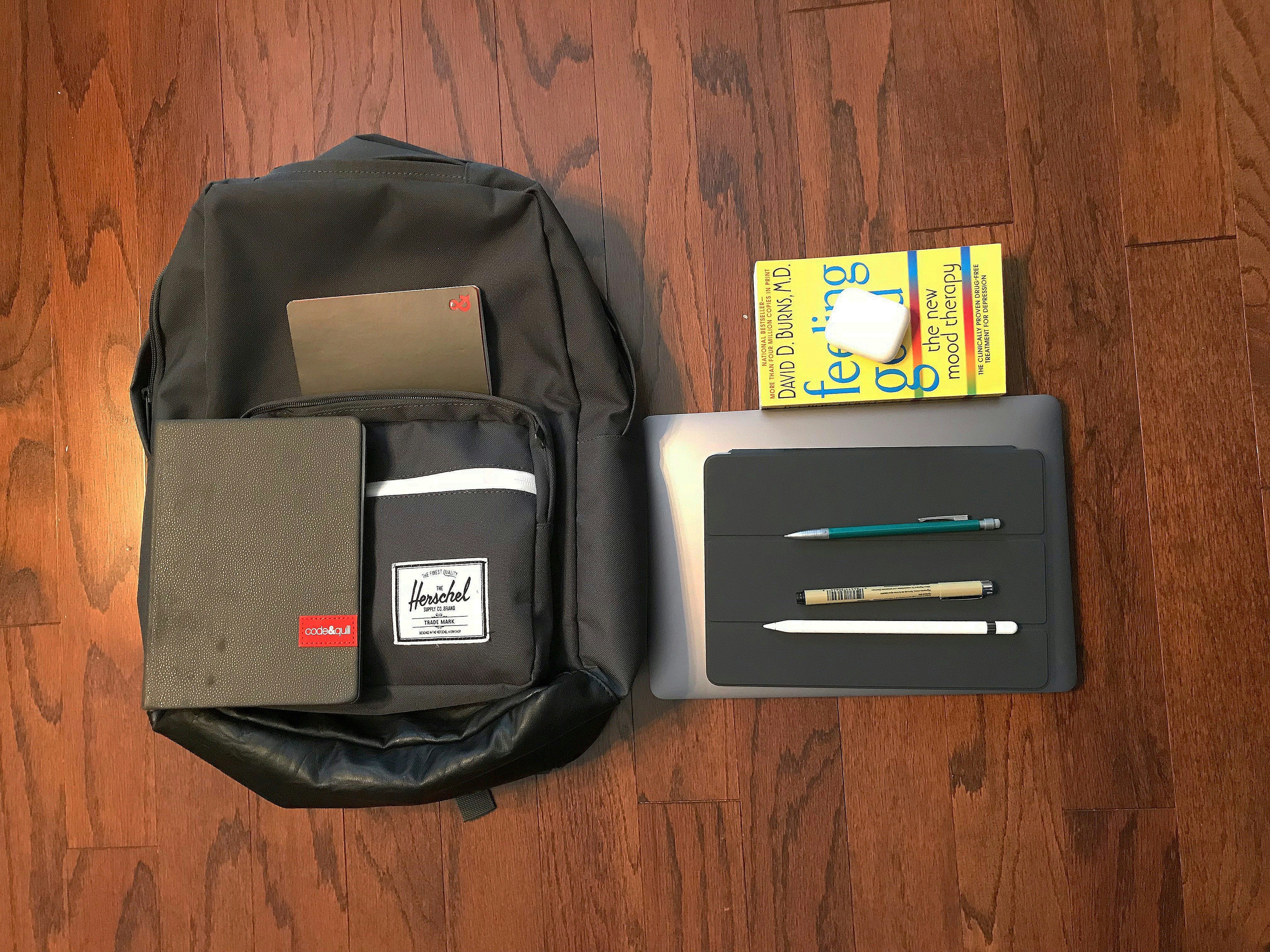 Dark grey laptop backpack on wooden floor with clean minimal background