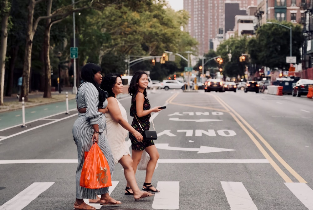 três mulheres caminhando na faixa de pedestres