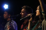 The trio passionately performing on stage with warm lighting highlighting their connection.