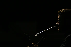 Close-up of a speech therapist gently guiding a patient during a vocal exercise