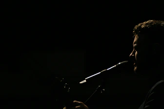 Close-up of a speech therapist gently guiding a patient during a vocal exercise