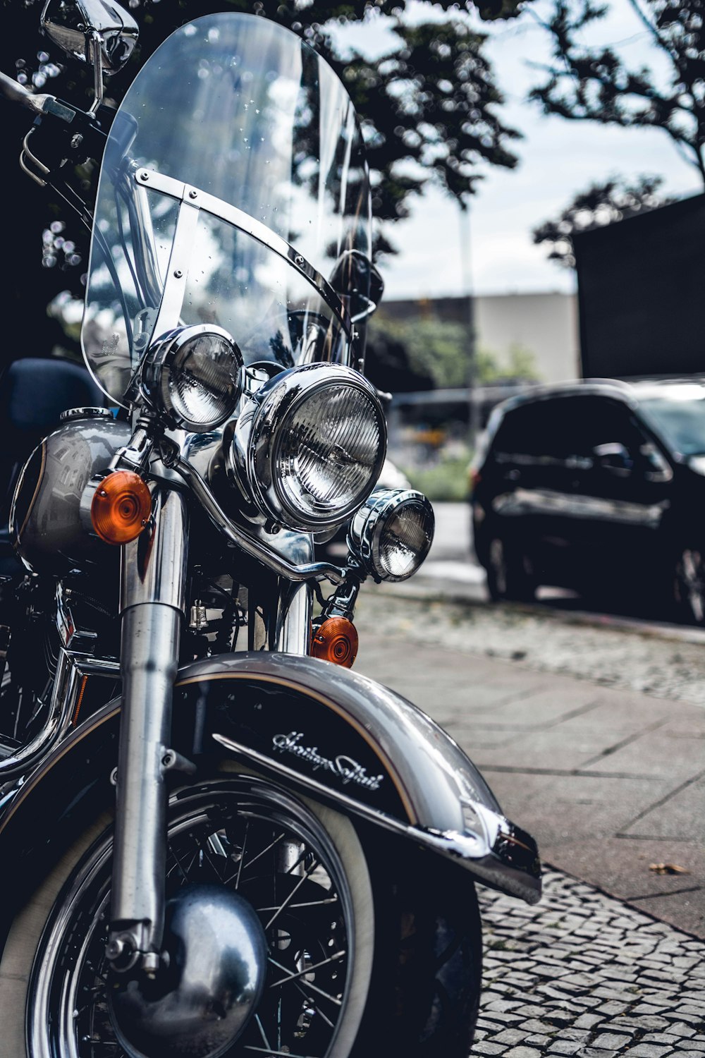 gray touring motorcycle parked on sidewalk at daytime