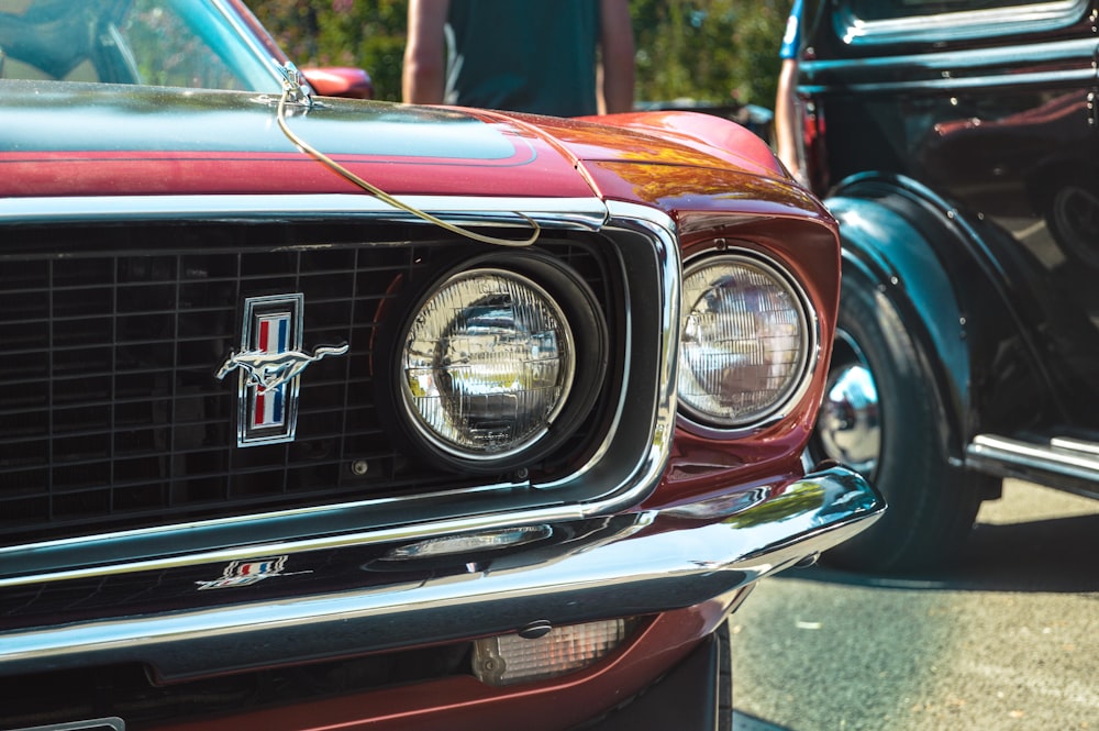 red Ford Mustang Grande parked near black vehicle