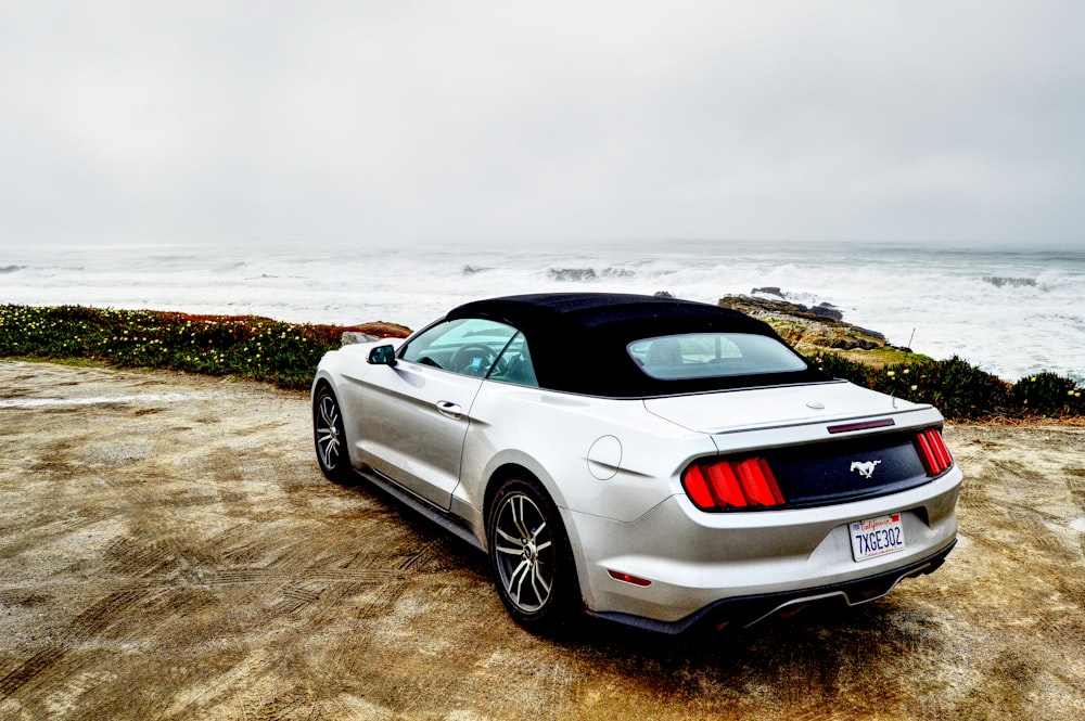 gray coupe parked near seashore