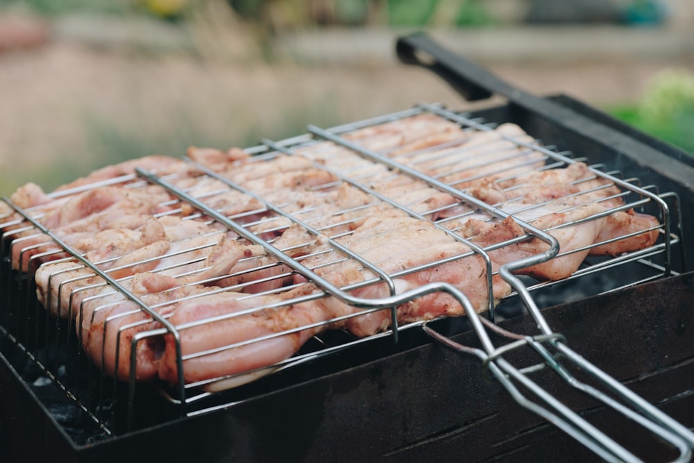 raw meat in gray handheld grill holder