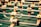 Several foosball player figures attached to rods are positioned on a green foosball table. The figures are wearing white shirts and black shorts, with the focus on one figure in the foreground.