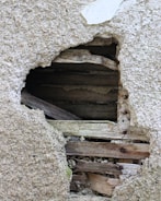 Close-up of detailed construction damage on a wooden beam indoors