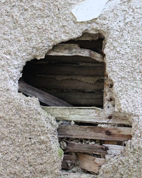 Close-up of detailed construction damage on a wooden beam indoors