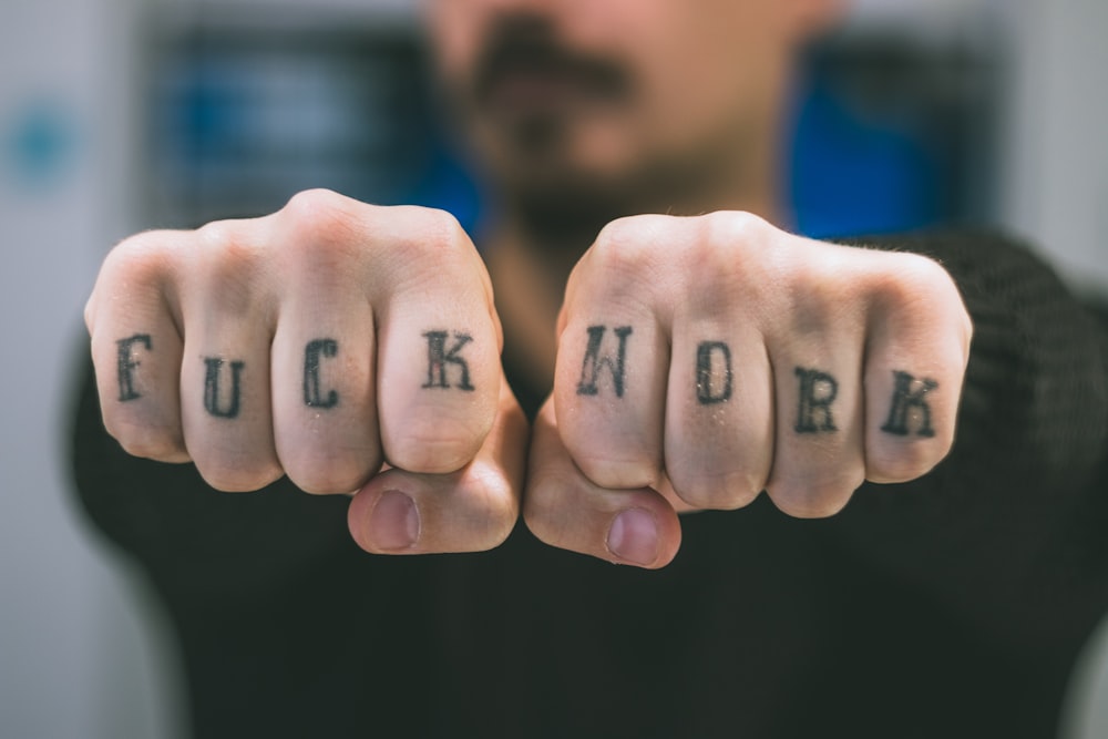 man showing his tattoos on hand