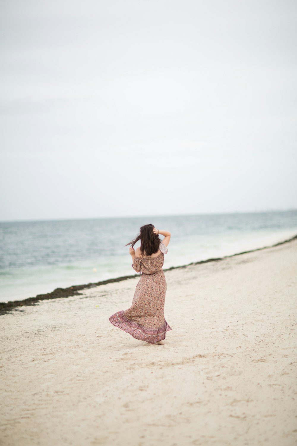 昼間の浜辺に立つ女性
