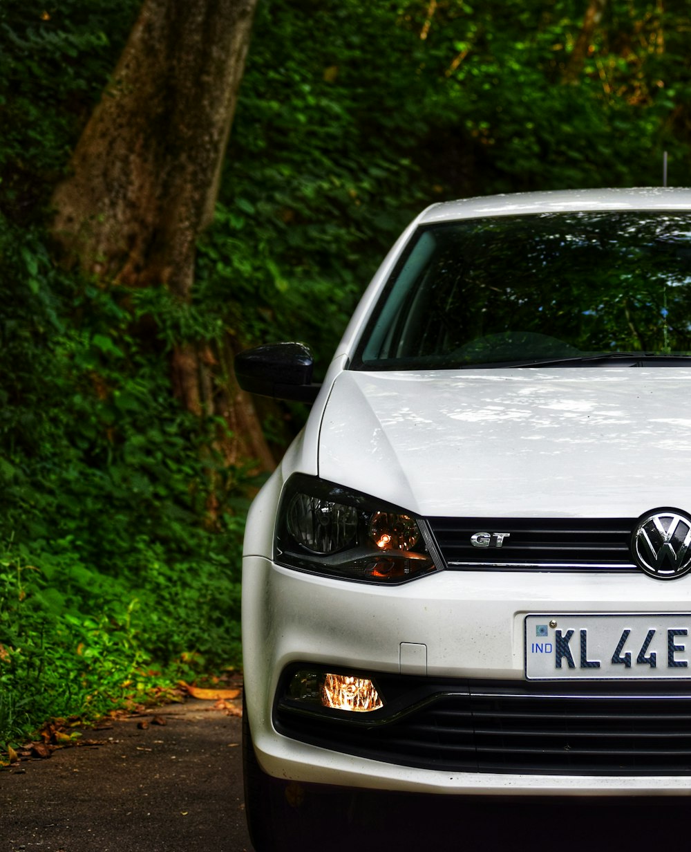 white Volkswagen car beside tree