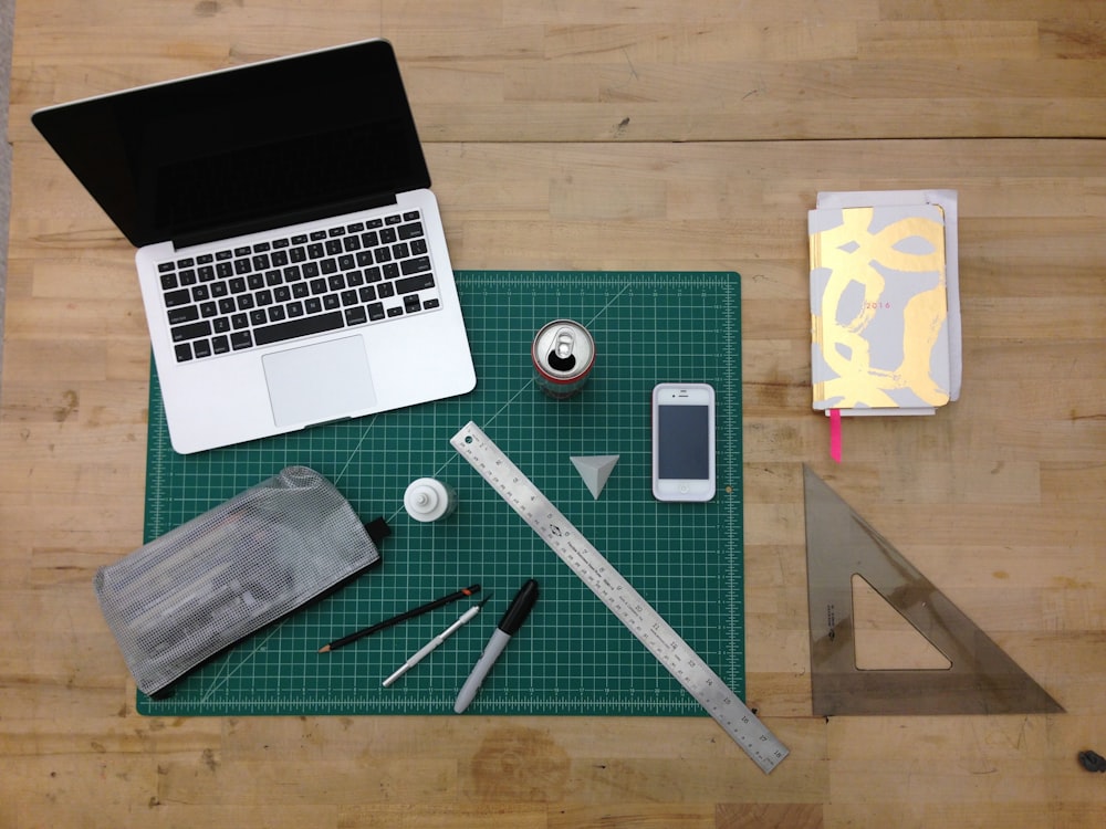 flat lay photography of MacBook, ruler, and can