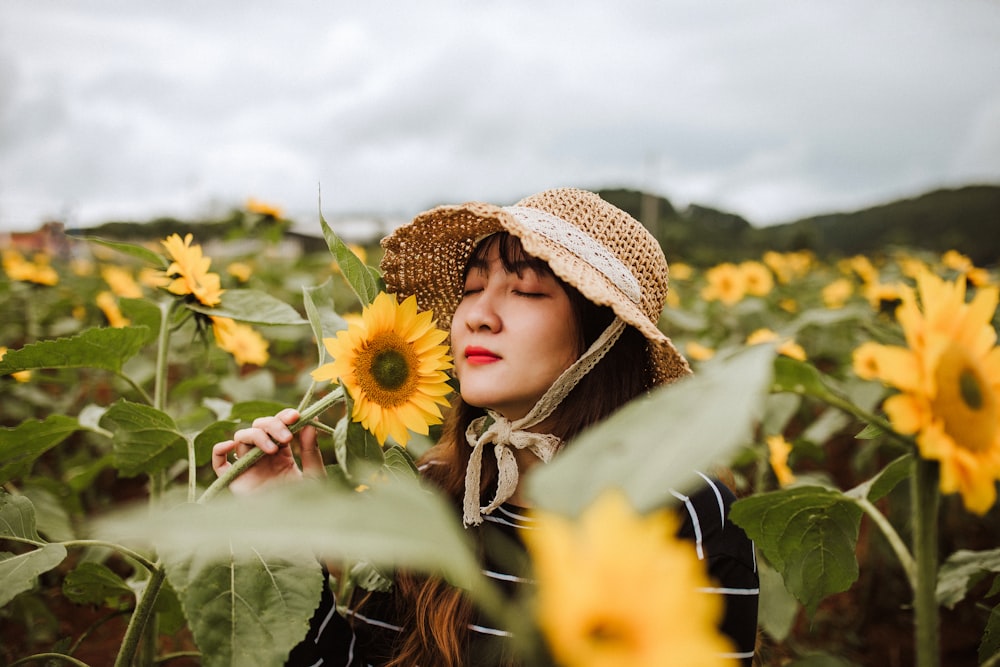woman in sunflower field smelling sunflower