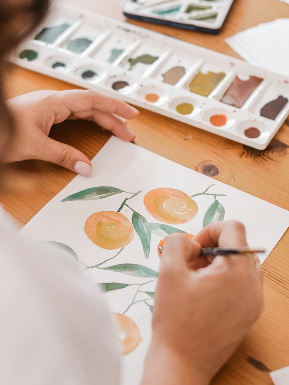 Person, die eine orangefarbene Frucht malt