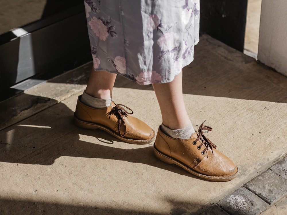 person wearing pair of brown leather shoes