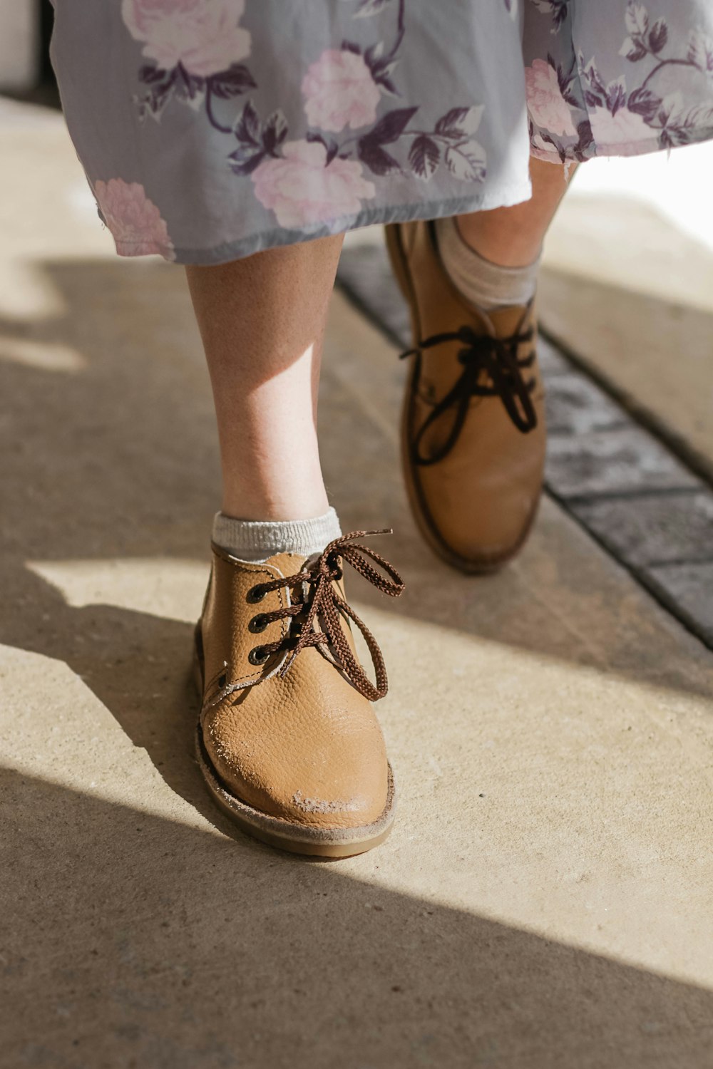 woman in pair of brown leather shoes