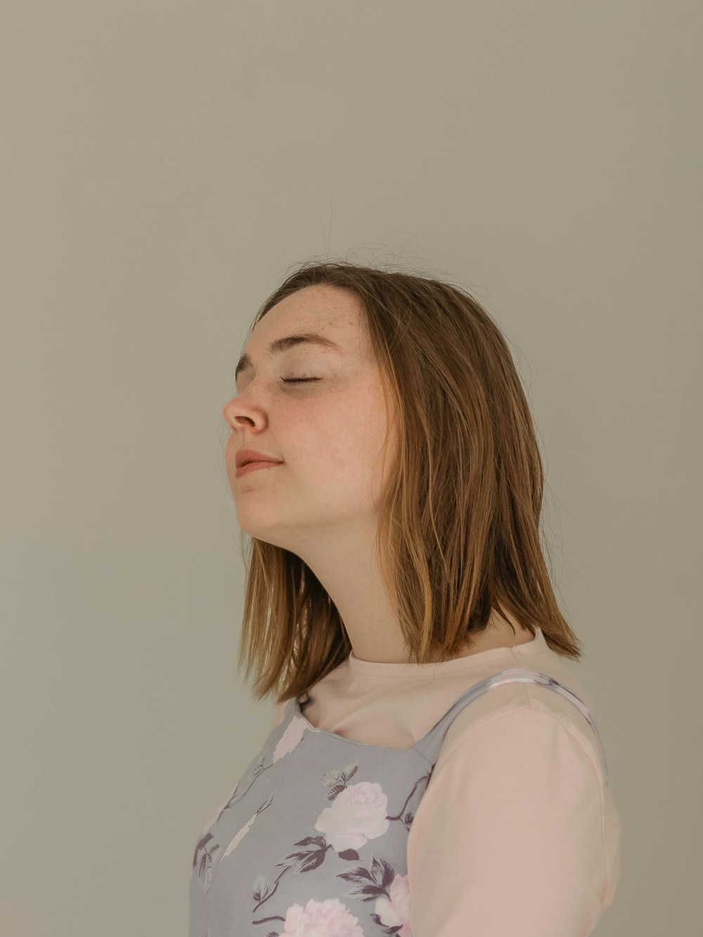 woman in gray and white floral top