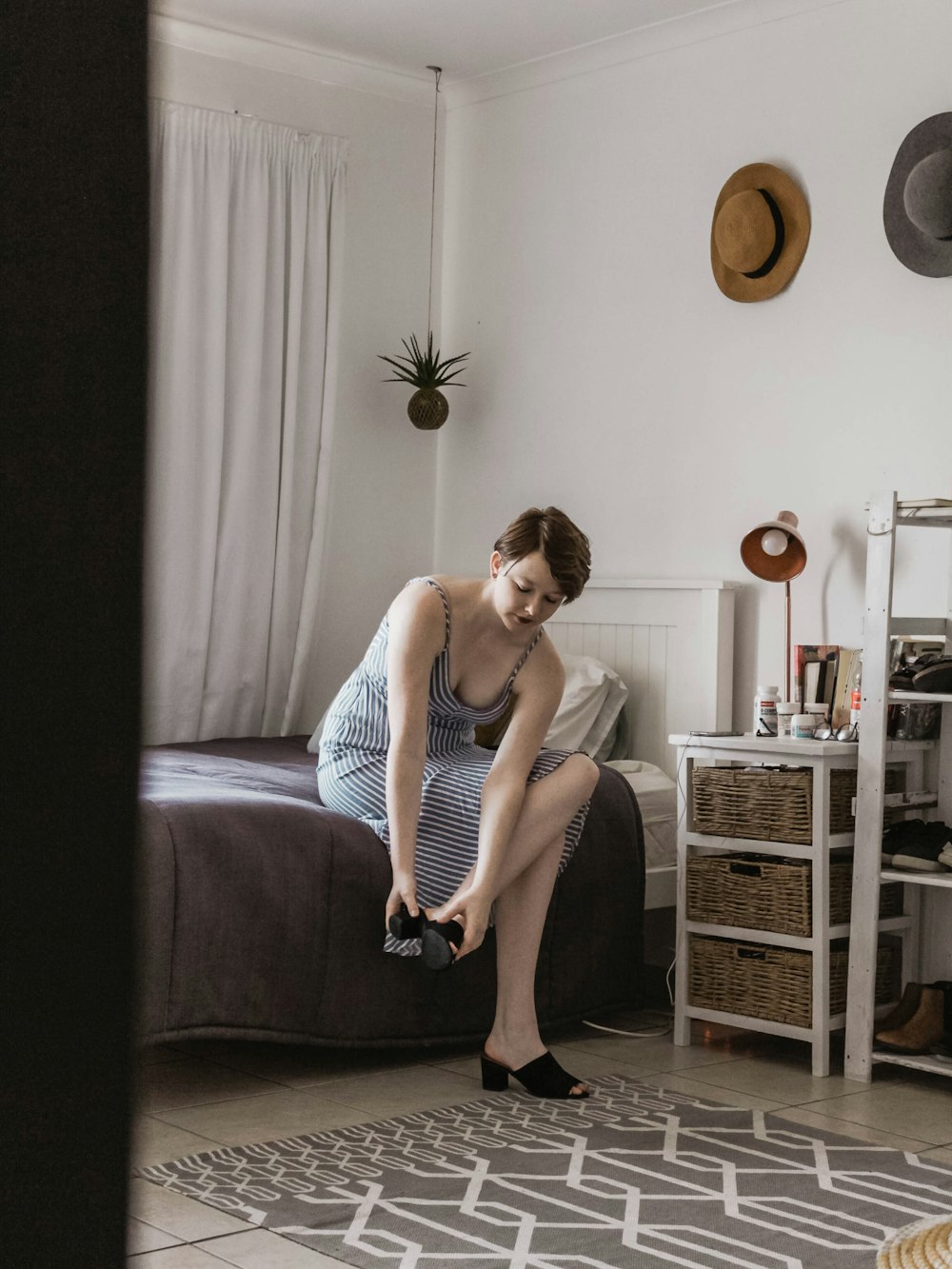 woman sitting on bed wearing sandals