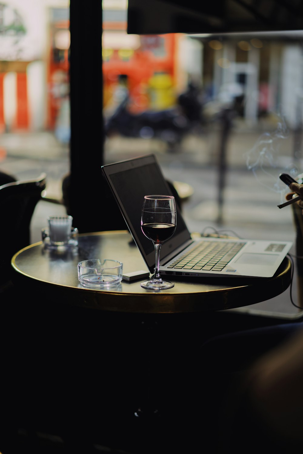 filled clear footed wine glass in front of laptop