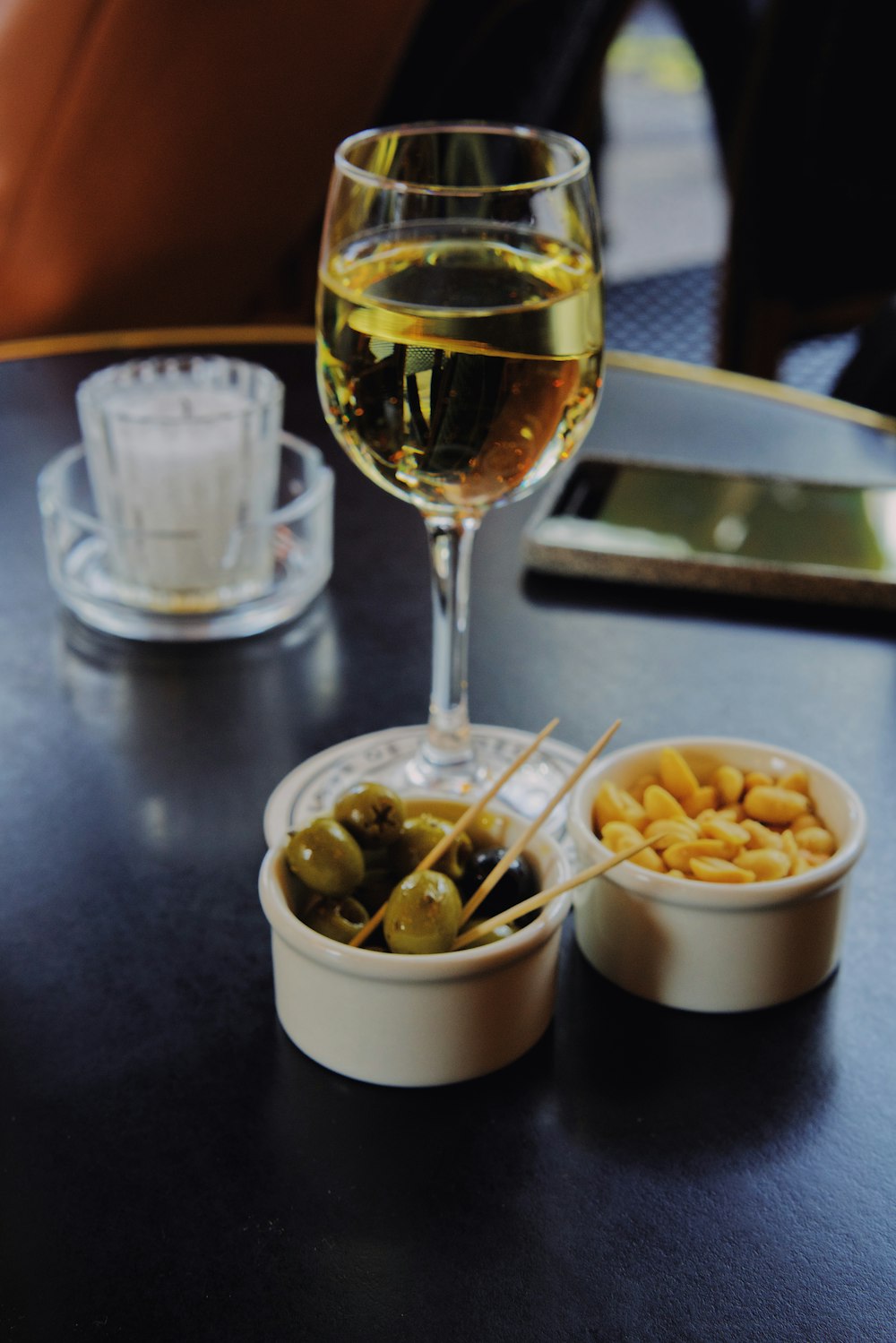 clear wine glass, brown peanuts, and round gray fruits