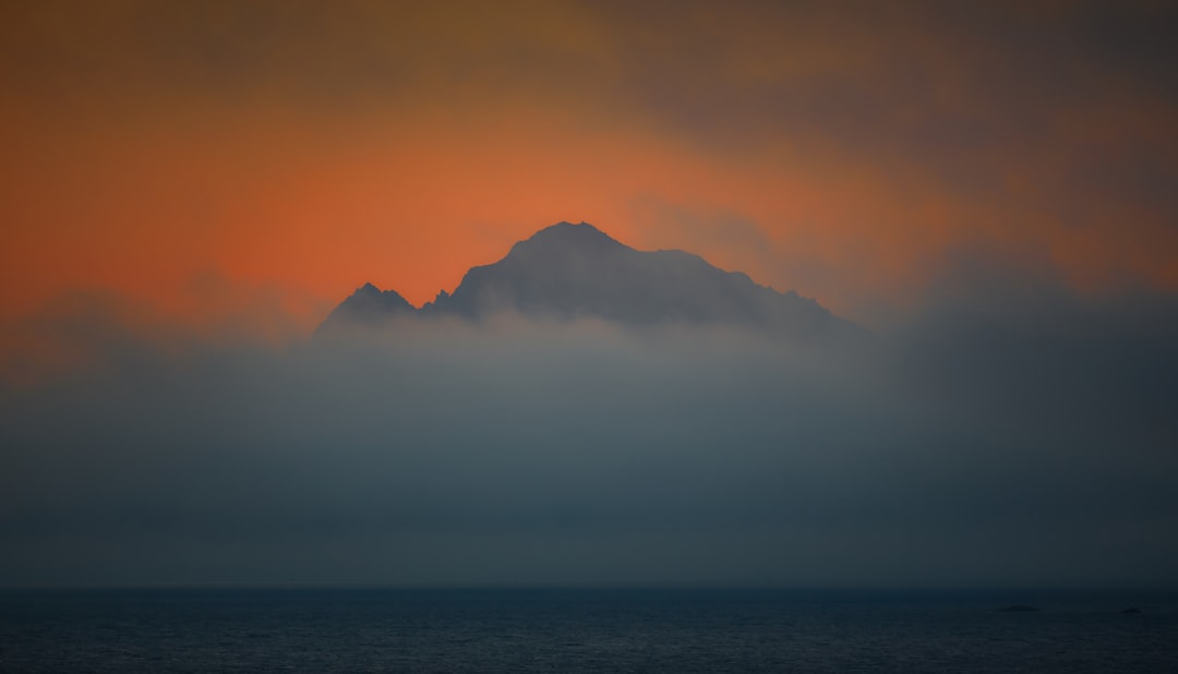 mountain surrounded with clouds painting