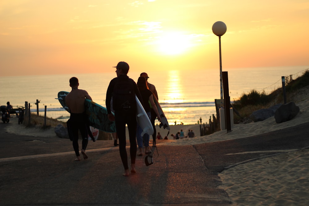 a group of people walking down a street with surfboards