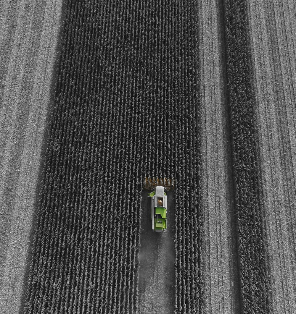 selective focus photography of a vehicle harvesting crop in a field
