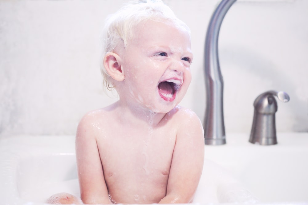 portrait photography of baby laughing