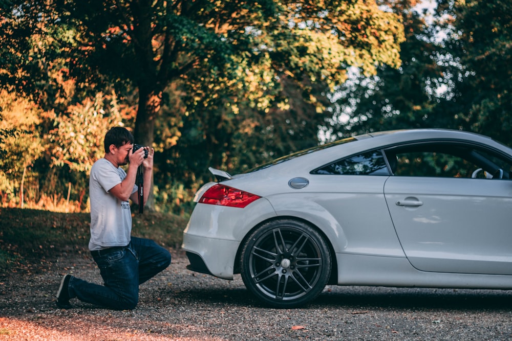 man taking photo of car