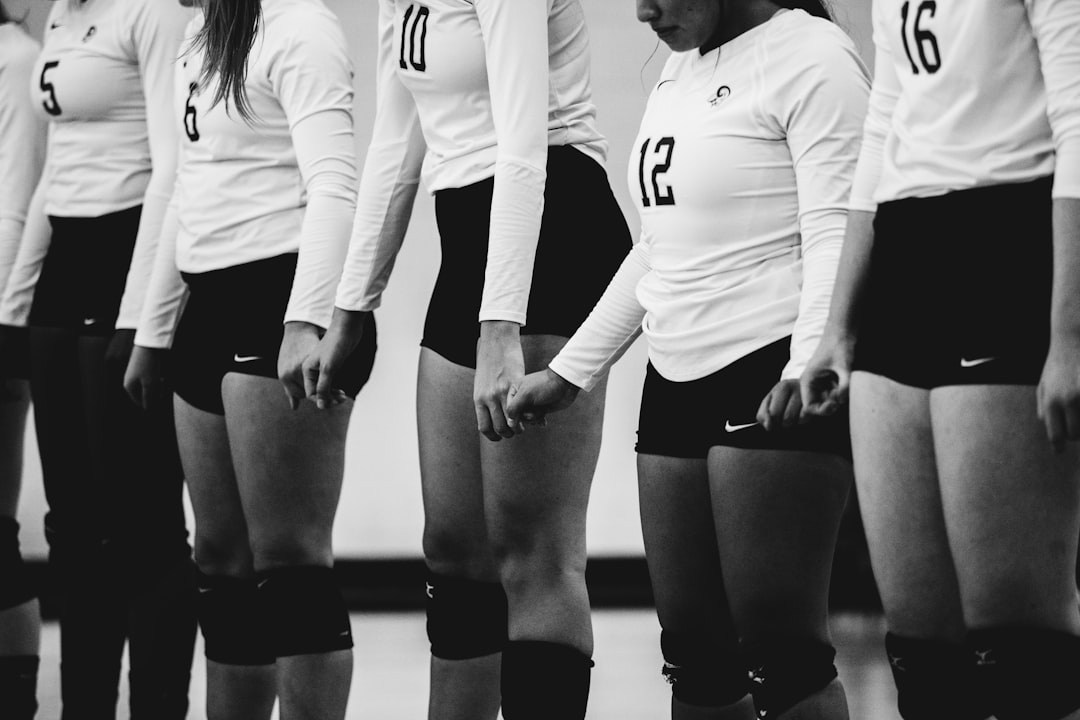 grayscale photography of women volleyball team lined up together