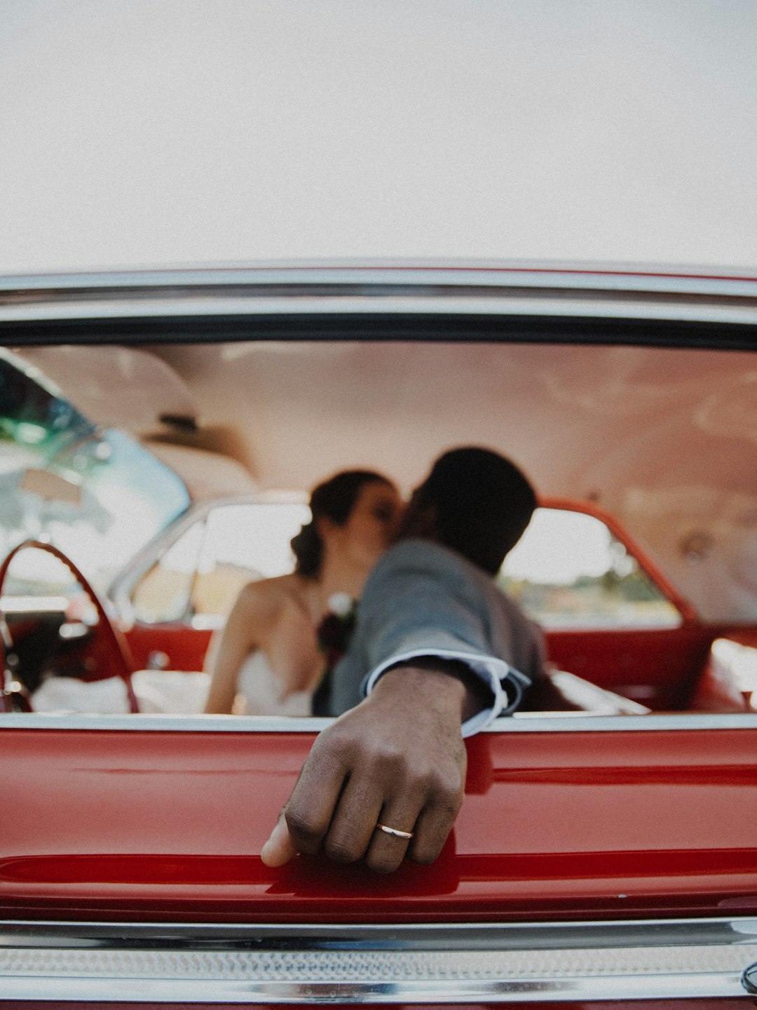 bride and groom kissing inside the car