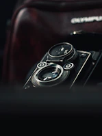 Close-up of a vintage camera with blurred wedding scene in the background.