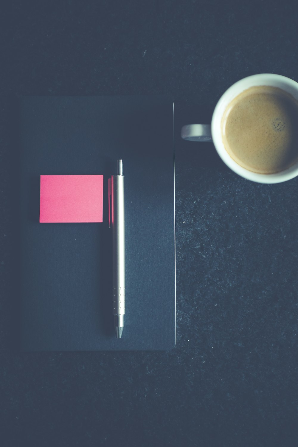 click pen on book beside the mug