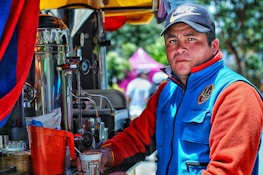 A professional team member in tan attire engaging with a high-end client beside an emerald green branded vending machine.