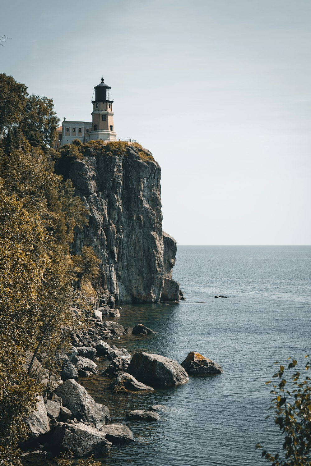 lighthouse above cliff near seashore