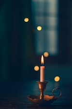 wax candle lit on brass candle holder