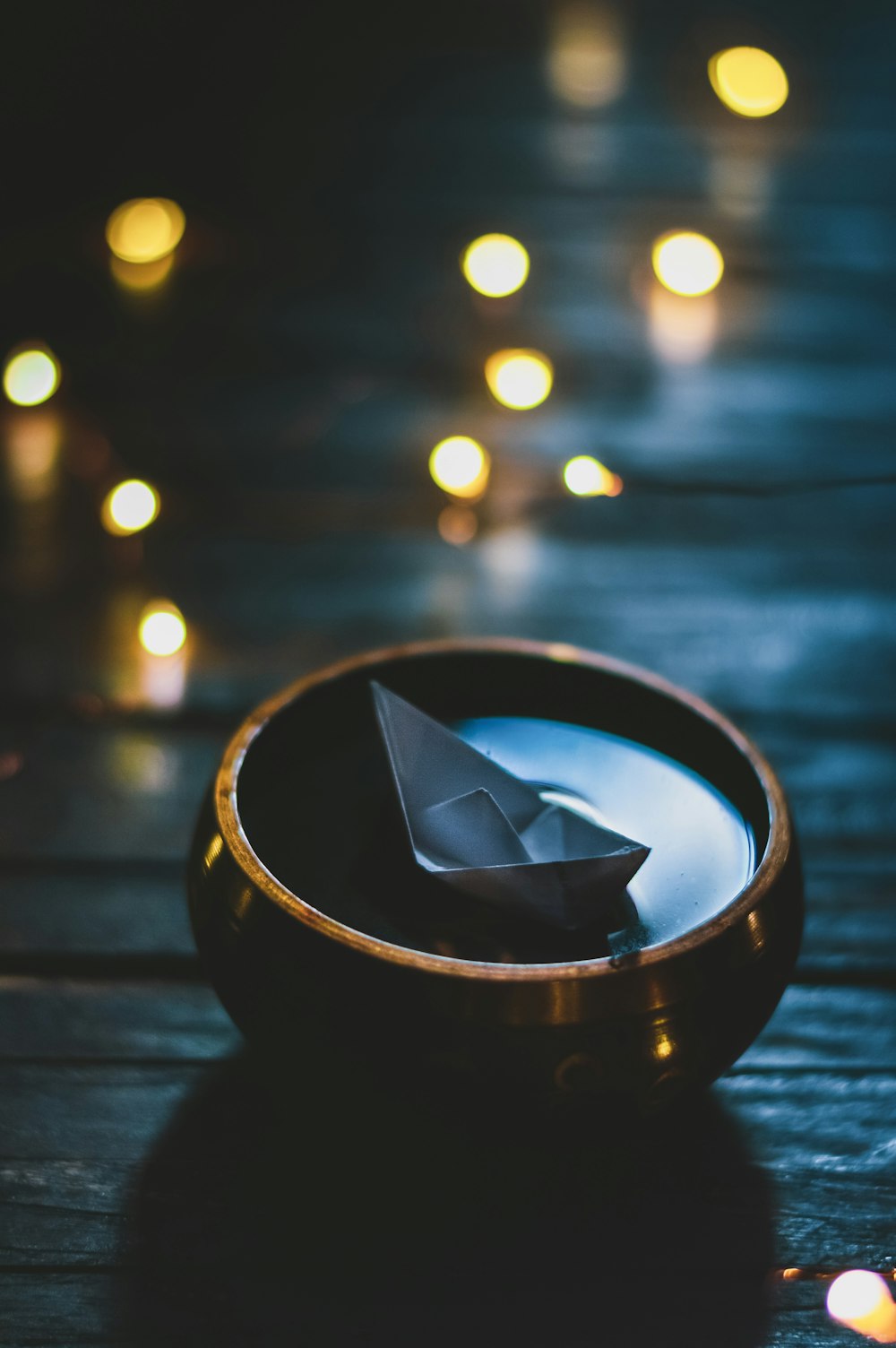 selective focus photograph of paper boat on bowl