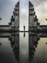 man standing between ruins in reflective photography