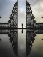 man standing between ruins in reflective photography