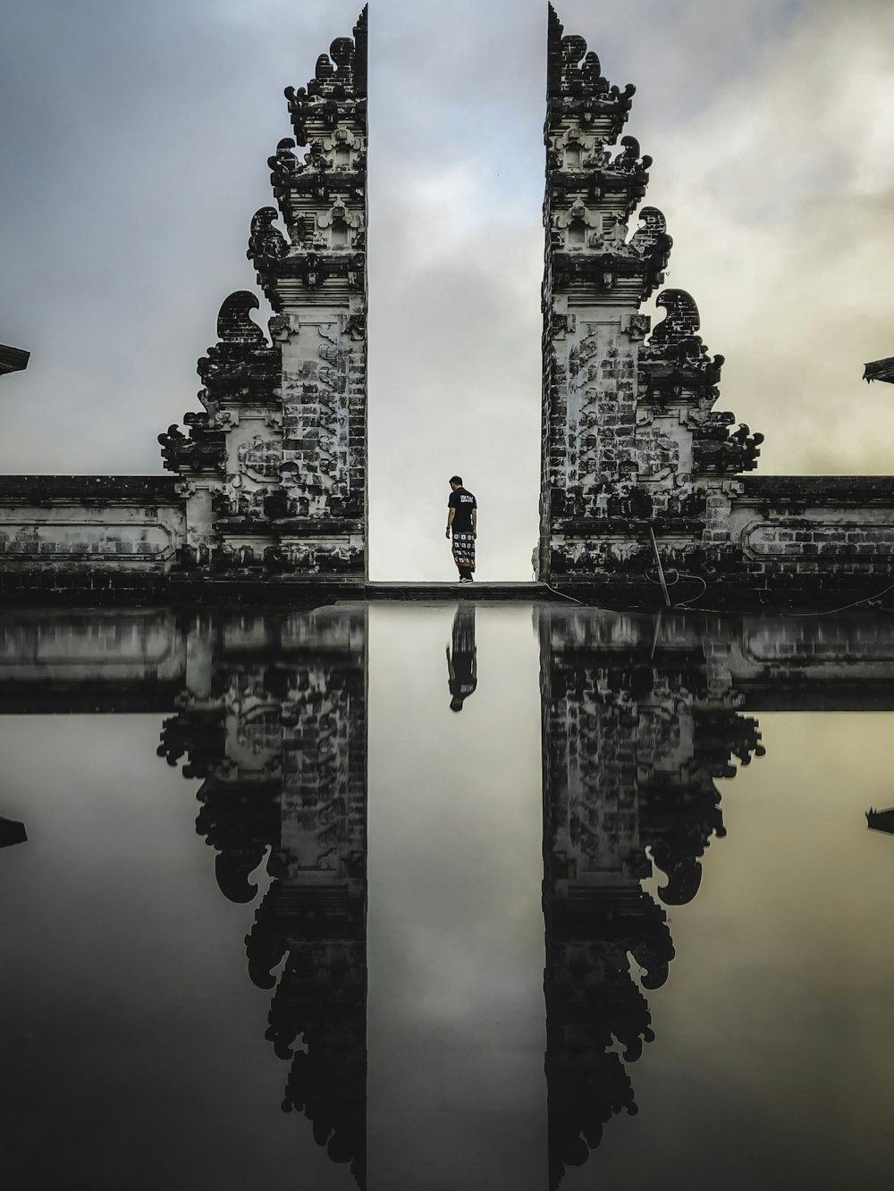 man standing between ruins in reflective photography