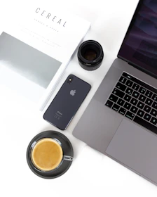 A neat desk with various digital gadgets and a cup of coffee, suggesting a review session.