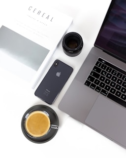A stack of tech magazines with a cup of coffee beside them.