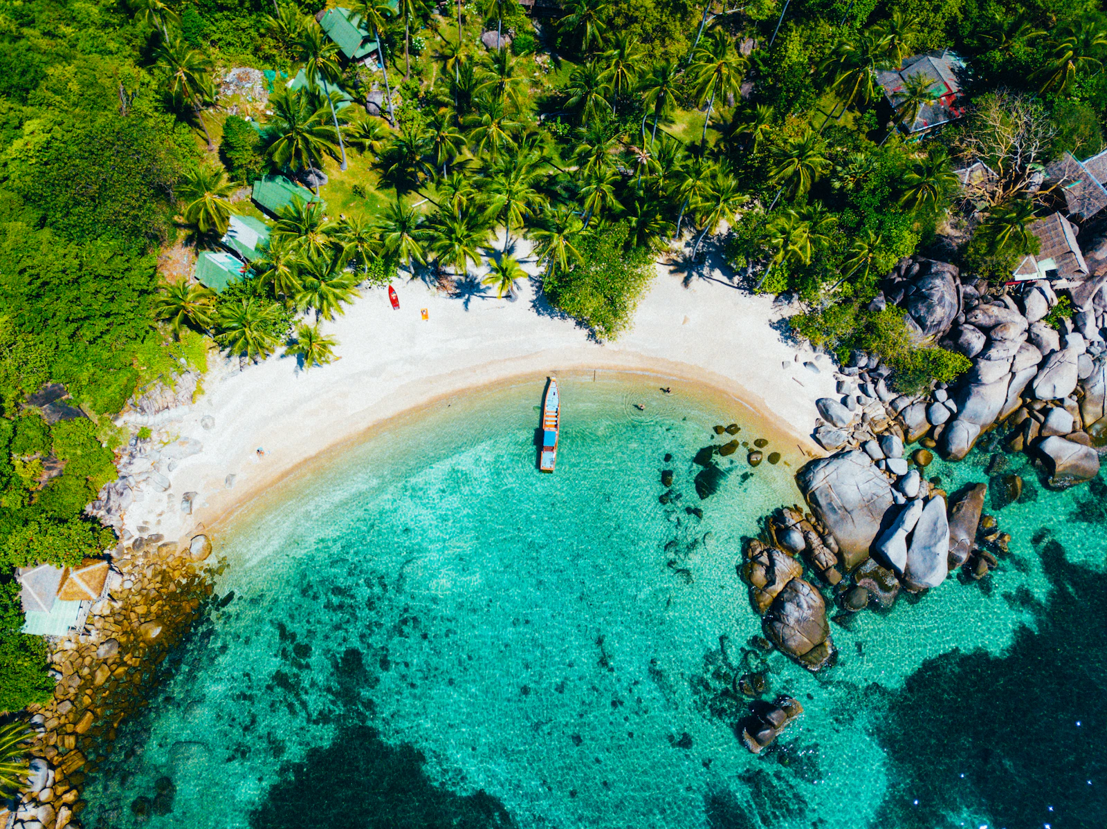 A longtail boat resting in the turquoise shallows of the Ang Thong Marine Park.