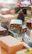 A collection of artisanal soap bars with various patterns, including swirls and geometric prints, stacked and displayed. The focus is on the texture and diversity of the designs, suggesting a handcrafted, festive theme with a pine cone in the background and colorful decorative items scattered around.