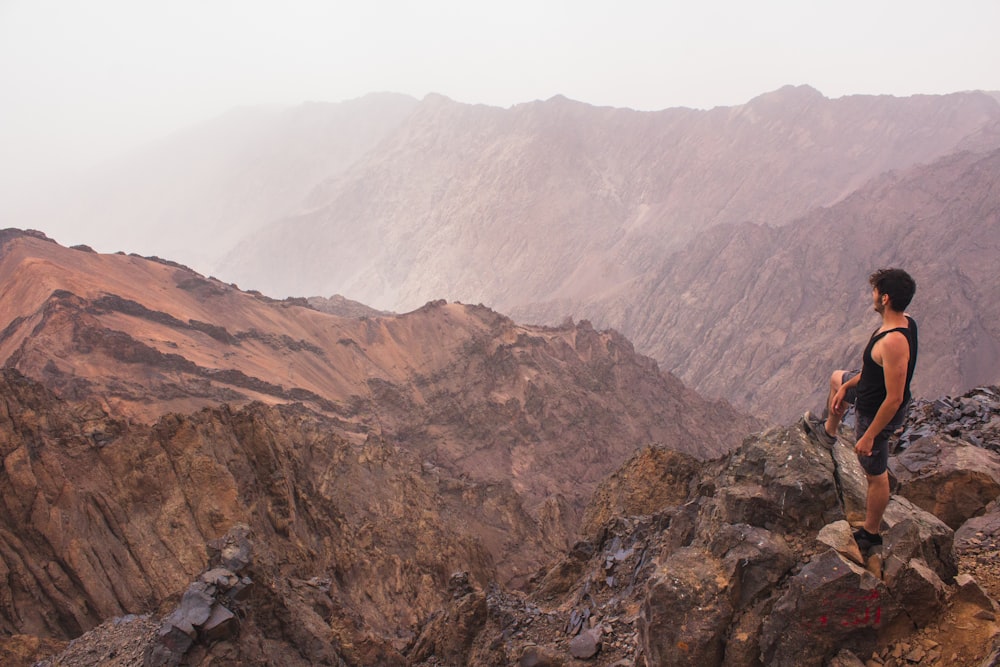 man standing on rock cliff