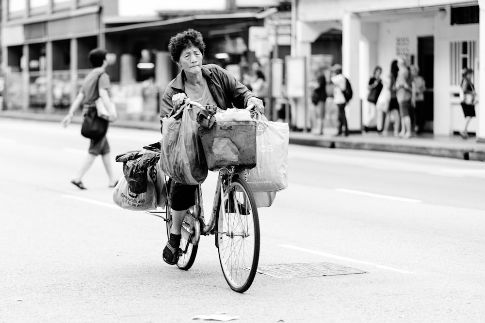 grayscale photography of woman riding bicycle
