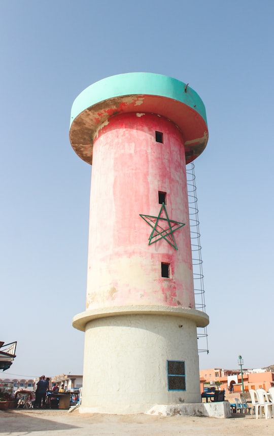 worms eye view of red and white concrete building in Imsouane Morocco