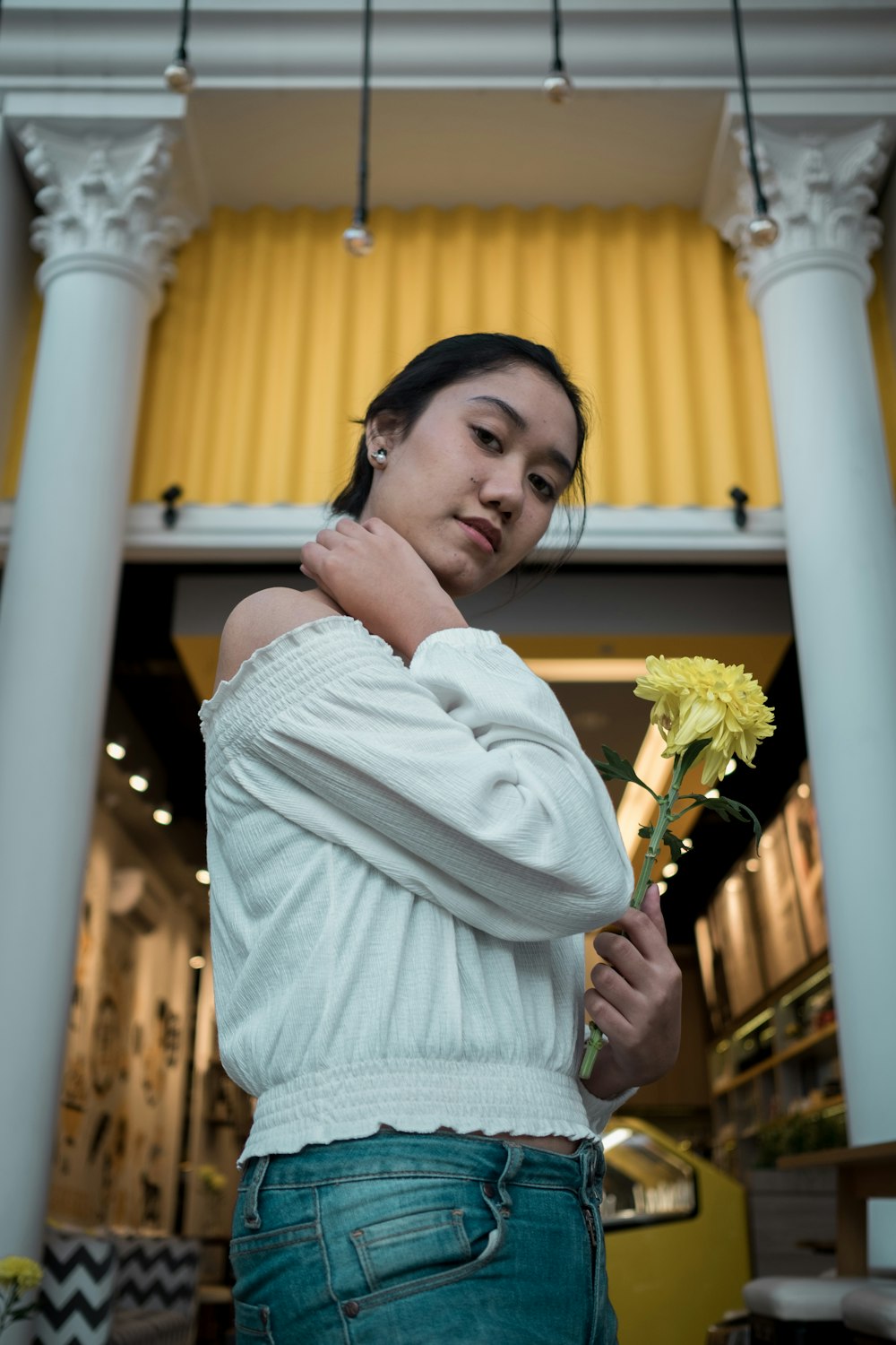 woman in white knit sweater holding white flower