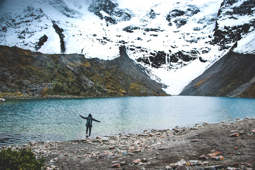 Persona in piedi vicino al lago durante il giorno