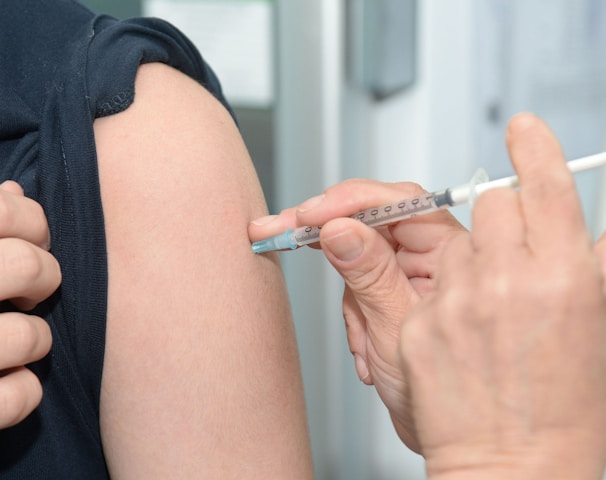 person injecting someone on his arm
